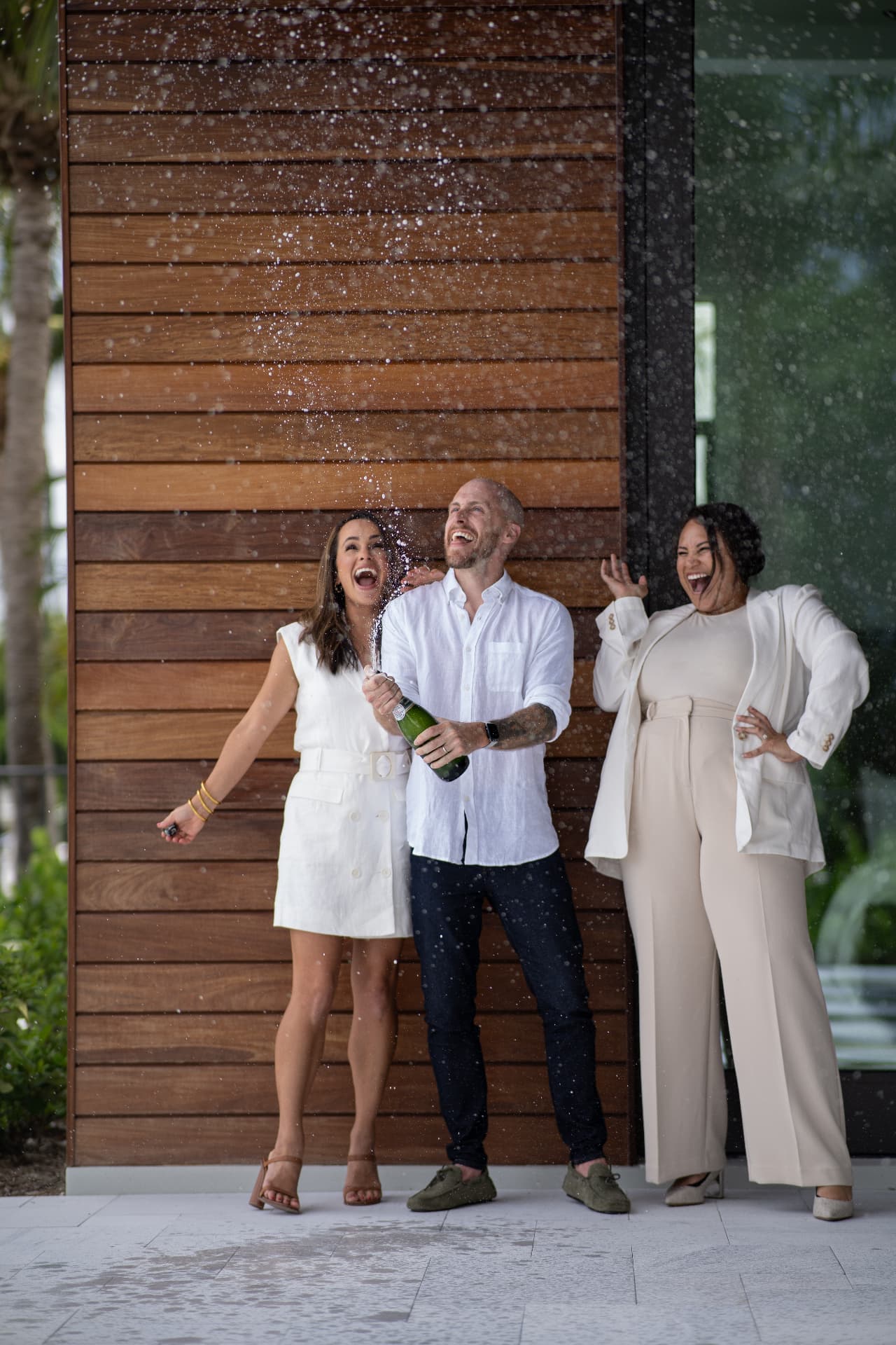 The Team Slayen agents celebrating a closing outside a modern waterfront home