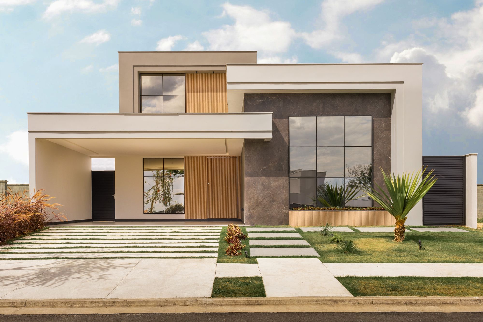 Newly completed limestone residence with young landscaping and an open motor court