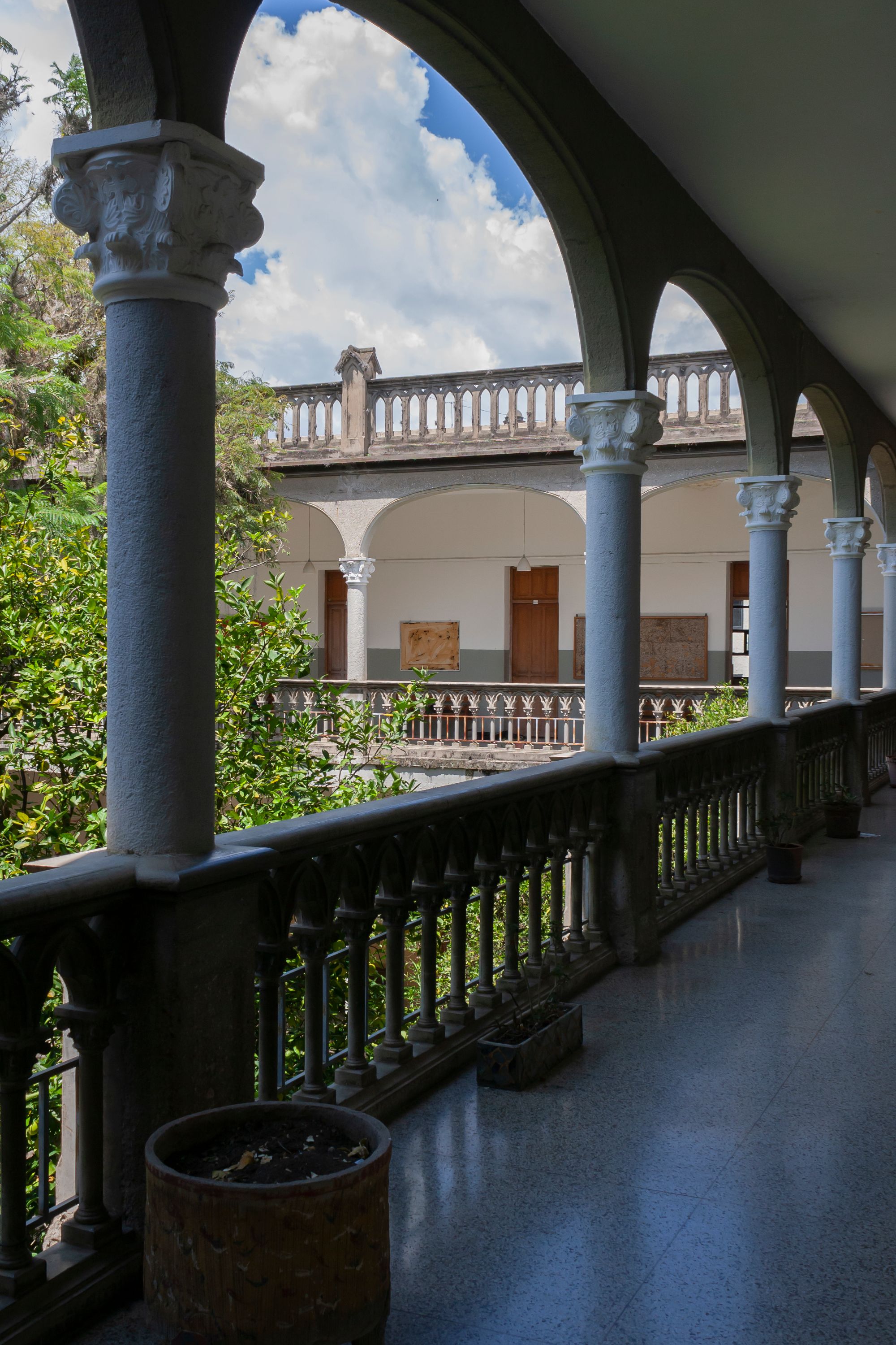 Limestone loggia with palm shadow across a plaster wall and a single linen chair at golden hour