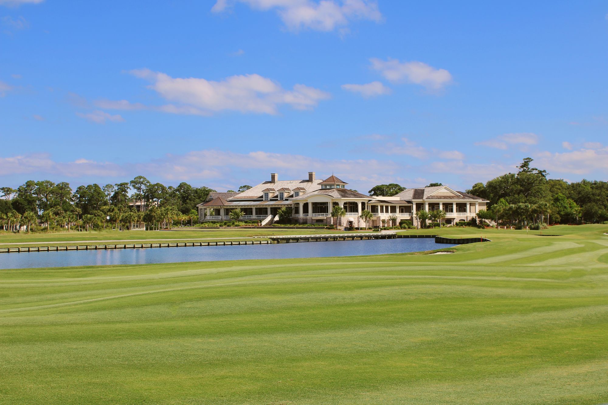 Limestone gatehouse and royal palm allée at the entrance of a private club community
