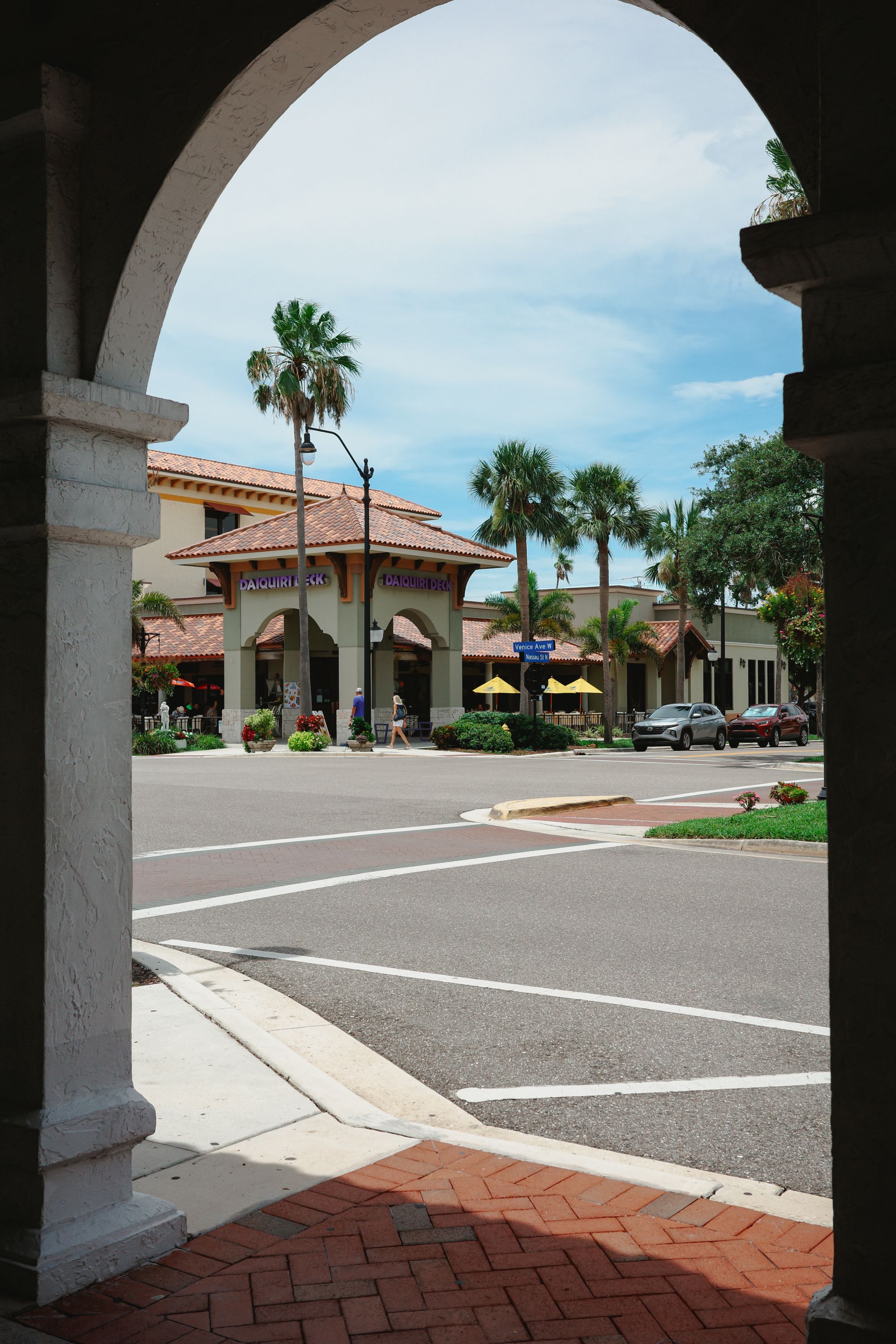 Walkable downtown street of white stucco storefronts and royal palms in West Palm Beach